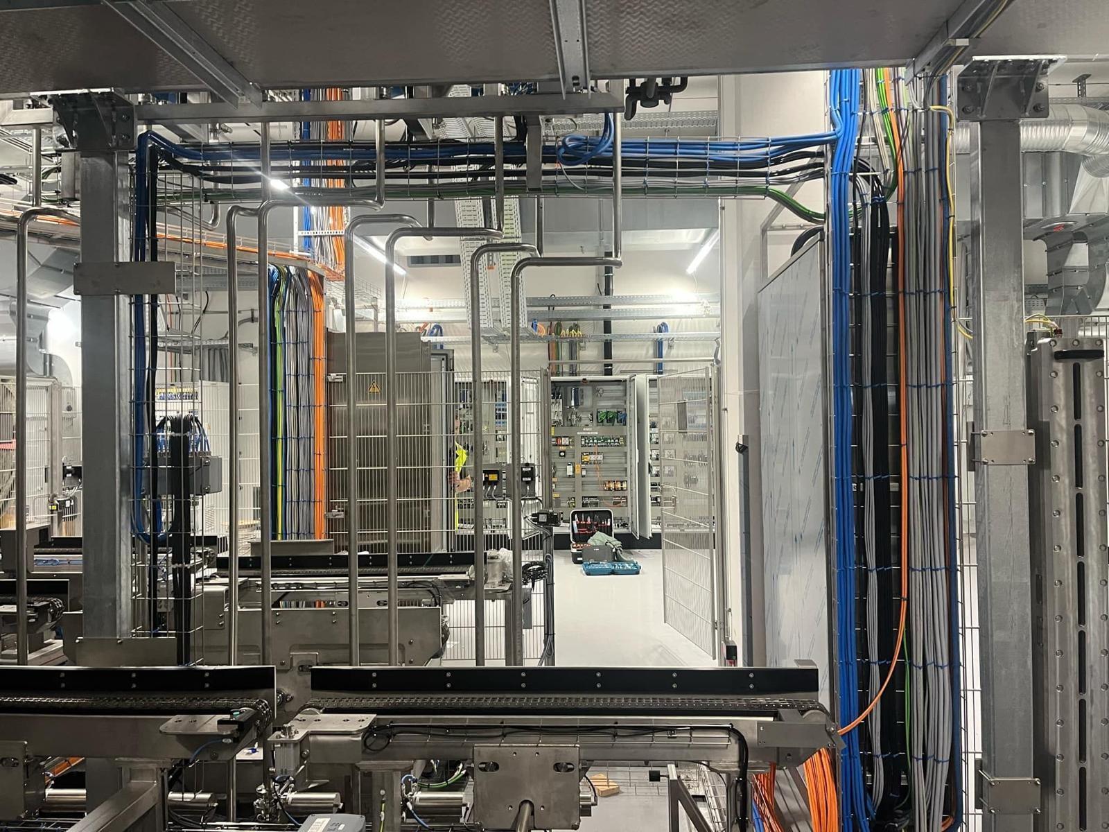 Verkabelung in Kabeltrassen über den Förderbändern einer Produktionslinie
