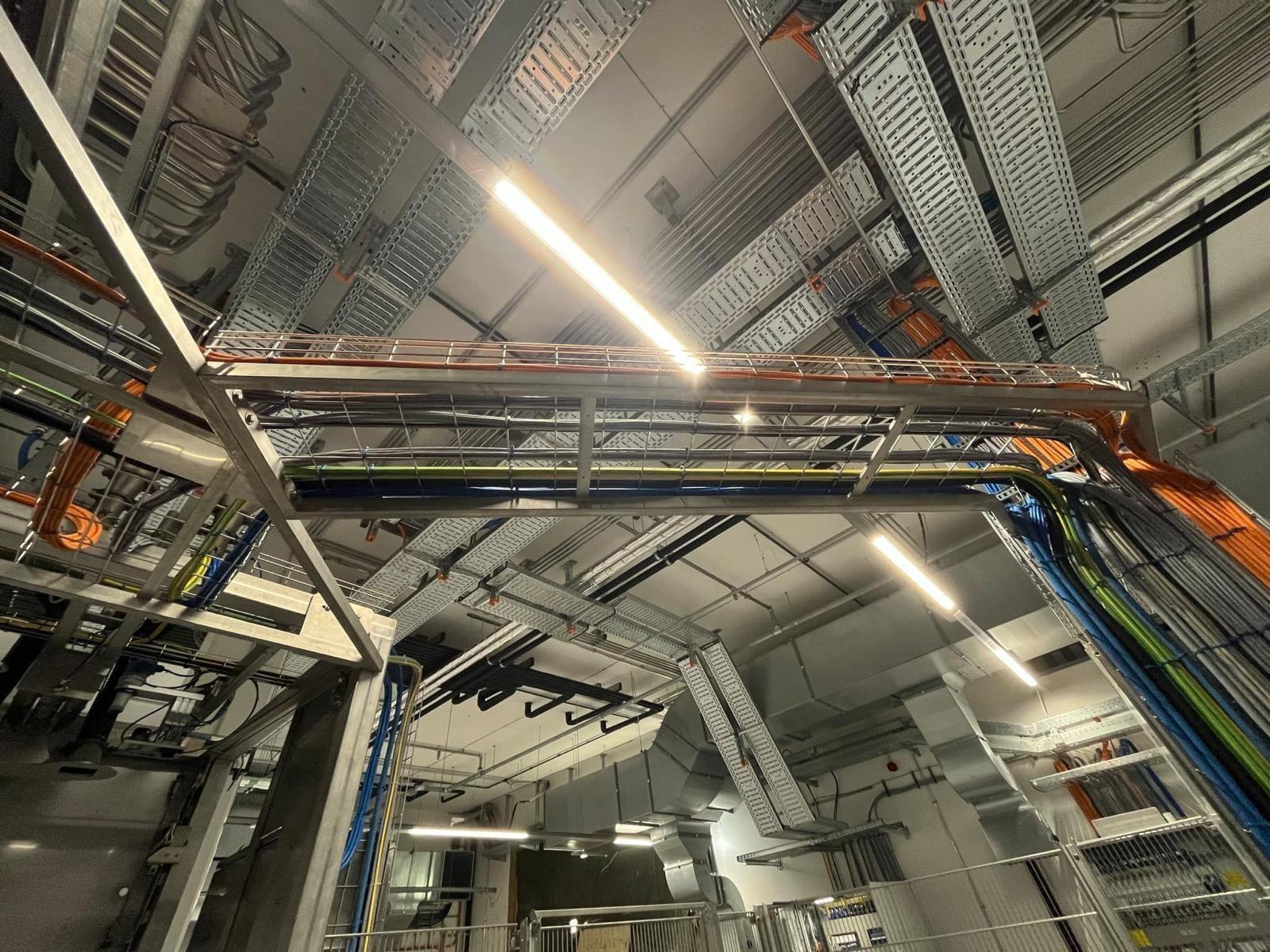 Kabeltrassen und Verkabelung unter der Decke einer Industriehalle