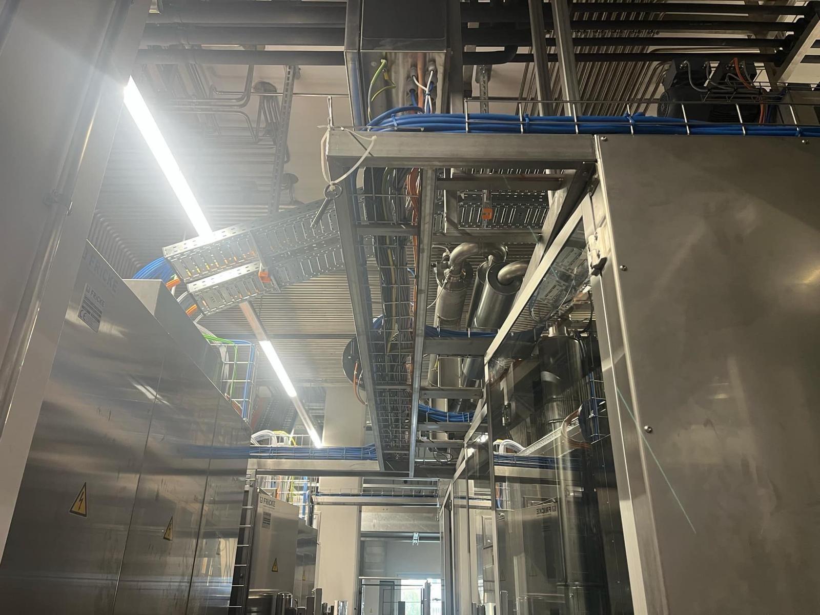 Kabeltrassen über Maschinen in einer Produktionshalle